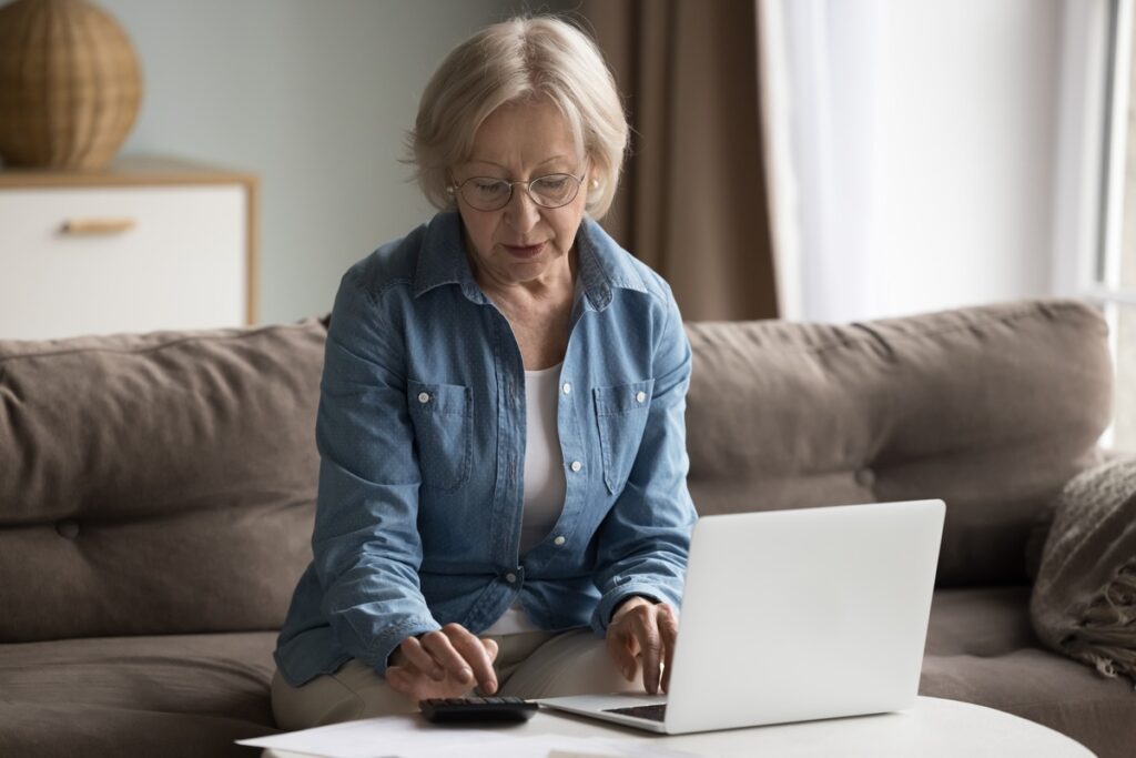 Older woman doing budget on her laptop